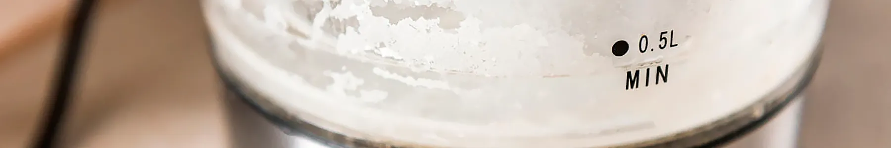 Белый осадок из карбоната кальция на дне чайника после кипячения жёсткой воды